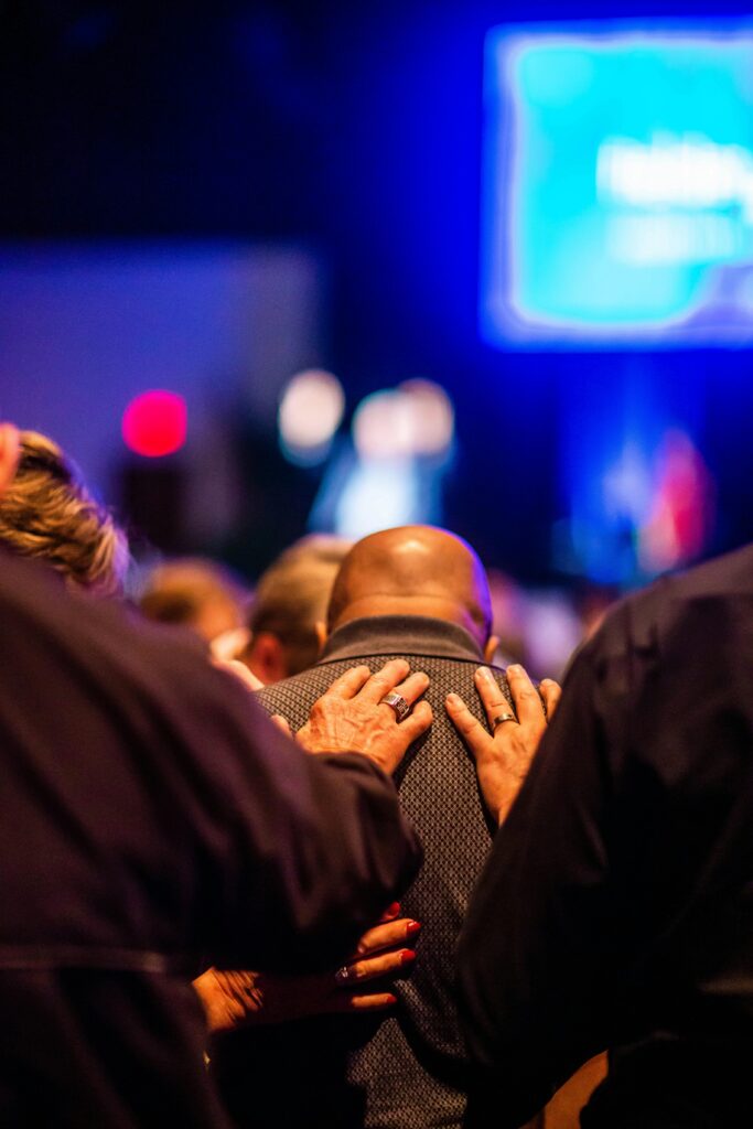 pexels-photo-34501065-34501065 A group of people supporting each other in prayer during a church event, conveying a sense of community and faith.
